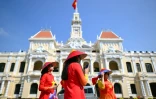 Des femmes portant des robes traditionnelles "Ao Dai" devant le siège du Comité du Peuple à Ho Chi Minh Ville, le 29 avril 2025