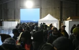 Des migrants rassemblés devant le centre de transit, un grand hangar désaffecté, le 2 octobre 2016 à Calais