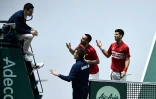 Les Serbes Viktor Troicki (c) et Novak Djokovic (d) discutent avec l'arbitre lors de leur match de double contre la Russie en Coupe Davis, le 22 novembre 2019 Ă Madrid