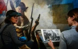 Des restaurateurs travaillent sur le tableau "La liberté guidant le peuple" d'Eugène Delacroix, dans un laboratoire du Musée du Louvre à Paris, le 28 février 2024