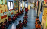 Des élèves dans "l'école du feu rouge", qui accueille des enfants défavorisés dans des conteneurs aménagés en salles de cours sous un pont autoroutier, le 18 mai 2026 à Bombay