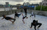 Le formateur Vikram Godakiya (debout) donne un cours de Cours de hip-hop ou "b-boying" sur le toit d'un immeuble du quartier de Dharavi, à Bombay, le 2 juillet 2021