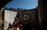 Armand Kisha déblaie les gravats dans sa maison détruite par un incendie de forêt à Skenderbegas, près de Gramsh, dans le centre de l'Albanie, le 16 septembre 2025 