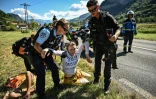 Des gendarmes évacuent des militants environnementaux le 12 juillet 2022 sur le tracé de la 10e étape du Tour de France. "La réalité, c’est que le monde vers lequel nous envoient les politiques est un monde dans lequel le Tour de France ne pourra plus exister", a commenté une militante du groupe Dernière rénovation qui a revendiqué l'opération