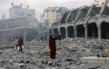 Une Palestinienne au milieu des décombres dans la cour d'une école où sont réfugiés des déplacés, touchée par une frappe israélienne la veille à Gaza-ville, le 4 avril 2025