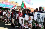 Des personnes montrent les portraits de manifestants tués, lors d'une manifestation à Khartoum le 30 décembre 2021 contre le coup d'Etat militaire du 25 octobre