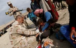 Un soldat irakien soigne une enfant blessée à Badouch dans un camp temporaire pour les familles qui ont fui les combats, le 8 mars 2017 au nord-ouest de Mossoul