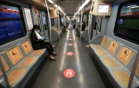 Une rame de métro dans laquelle une signalisation indique comment respecter la "distanciation sociale" à Milan, le 28 avril 2020 en Italie