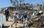 Des habitants portent des masques pour se protéger des mauvaises odeurs causées par les déchets et débris, le 6 novembre 2023 à Acapulco, deux semaines après le passage de l'ouragan Otis au Mexique