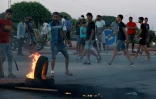 Des jeunes tunisiens bloquent la route aux migrants en mettant le feu à des pneus alors que la tension monte à Sfax après l'enterrement d'un jeune Tunisien poignardé à mort lors d'une échauffourée entre habitants et migrants d'Afrique subsaharienne, le 4 juillet 2023 