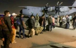 Des Français et des Afghans attendent pour embarquer à bord d'un avion de transport militaire français le 17 août 2021 à l'aéroport de Kaboul