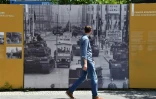 Le 22 juin 2020 à Berlin, devant un panneau portant une photo de Checkpoint Charlie du temps de l'Allemagne de l'Est et de l'Allemagne de l'Ouest