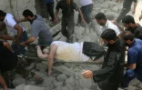 Un blessé extrait des décombres après un bombardement le 27 avril 2016 à Alep en Syrie