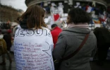 Une femme porte une tee-shirt sur lequel figurent les prénoms des victimes des attentats de janvier et novembre 2015, le 10 janvier 2016 à Paris