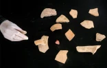 Une membre de l'association Mayasem pour la culture et les arts examine des tessons de poterie, dans le dépôt de patrimoine culturel à Khan Younès, dans le sud de la bande de Gaza, le 11 juillet 2026