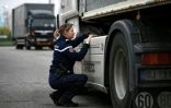 Une référente Sûreté du groupement de gendarmerie de Haute-Garonne vérifie le réservoir d'un camion de la compagnie de transport C'Express, le 16 mars 2022 à Castelnau-d'Estrétefonds, près de Toulouse