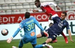 Le gardien de but marseillais Steve Mandanda dévie le tir de l'attaquant rémois Boulaye Dia, lors de leur match de L1, le 23 avril 2021 au stade Auguste Delaune