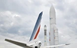 La dérive d'un avion Air France à côté de maquettes des fusées Ariane 1 (g) et Ariane 5 (d) au salon international aéronautique et de l'espace à l'aéroport Paris-Le Bourget, le 18 juin 2023