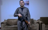 Aresto Pasbar, un Iranien qui a fui le pays après avoir rejoint les manifestations antigouvernementales de 2022, tient un fusil AK-47 dans une maison de Souleimaniyeh, le 13 mars 2026 en Irak