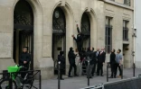 Un agent de sécurité retire une affiche à l'entrée de Sciences Po Paris, après que des étudiants ont pénétré à l'intérieur pour un rassemblement propalestinien, le 7 mai 2024 à Paris