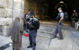 Un policier israélien contrôle les papiers d'idéntité d'une Palestinienne dans la Vieille ville de Jérusalem, le 16 juillet 2017