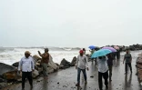 Des passants le long de la côte du golfe du Bengale, à Kakinada, en Inde, le 27 octobre 2026, avant le passage attendu du cyclone Arnab