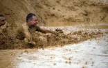 Un participant du "Mud day challenge", patauge dans la boue lors de la course d'obstacles, le 7 mai 2016 à Beyne près de Paris