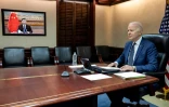 Le président américain Joe Biden (d) s'entretient avec son homologue chinois Xi Jinping (dans l'écran) par visioconférence depuis Washington, le 18 mars 2022