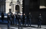 Des policiers montent la garde près du musée du Louvre le 3 février 2017 à Paris, après une attaque contre des militaires en faction par un homme armé d'une machette