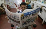 Un homme lit le journal dont la "Une" annonce la réélection du président Daniel Ortega, le 7 novembre 2016 à Managua, au Nicaragua