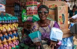 Kehinde Bakare, 61 ans, montre des boîtes en plastique et en polystyrène qu'elle vend dans son échoppe à Lagos, mégapole de plus de 20 millions d'habitants, le 23 janvier 2024.