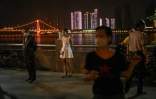Des habitants de Wuhan portant des masques de protection dansent le long du fleuve Yangtsé, en Chine, le 13 mai 2020.