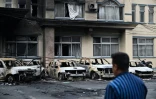 Un habitant passe devant des voitures calcinées pendant un couvre-feu à Katmandou, le 12 septembre 2025 au Népal
