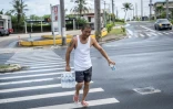 Un homme porte un pack de bouteilles d'eau à Guam alors que le typhon Bavi approche de l'île américaine du Pacifique le 5 juillet 2026