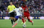 Le Français Eduardo Camavinga (g) face au Canadien Alphonso Davies, le 9 juin 2024 à Bordeaux