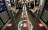 Une rame du métro de Milan avec des autocollants au sol portant l'inscription "Mettez-vous ici", le 28 avril 2020