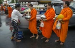 Des moines reçoivent des offrandes, le 23 octobre 2018 près d'un temple bouddhiste à Bangkok