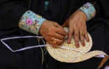 Une femme émiratie tisse des feuilles de palmier lors d'un festival du patrimoine à Al-Ain, aux Emirats arabes unis, le 10 novembre 2023