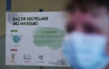 Une affiche d'information sur un bac de recyclage de masques dans un couloir de l'hôpital Saint-Antoine, le 30 avril 2021 à Paris