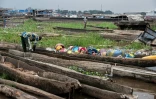 Un pĂȘcheur trie dans une pirogue des objets en plastique ramassĂ©s sur les rives du fleuve Congo Ă Kinshasa, le 27 avril 2026 en RDC