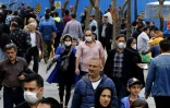 Des Iraniens, certains portant des masques, marchent dans le grand bazar de Téhéran, en pleine épidémie du coronavirus, le 18 mars 2020