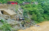 Des équipes de secours recherchent des survivants dans la rivière Trishuli après un glissement de terrain qui a emporté deux bus, le 12 juillet 2024 à Simaltar, au Népal