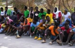Des migrants attendent devant le centre d'accueil de Lampedusa, le 16 septembre 2023 en Italie