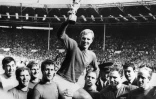 Le capitaine de l'équipe d'Angleterre, Bobby Moore, porté par ses coéquipiers, brandit le trophée de la Coupe du monde,  après la victoire de son équipe (4-2 en prolongation), en finale, le 30 juillet 1966 au stade de Wembley à Londres