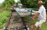 Des employés du "train de bambou" installent un chariot sur les rails, le 6 août 2017 à Battambang, au Cambodge