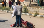 Une enfant palestinienne se tient devant le corps d'une personne tuée en venant chercher des vivres dans un site de distribution de la Fondation humanitaire de Gaza (GHF) soutenue par Israël et les Etats-Unis, dans le centre de la bande de Gaza, le 4 août 2025