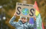 Une petite fille participant Ă la manifestation pour le climat Ă Berlin tient une pancart oĂą est inscrit "Mon avenir ?! SOS", le 22 octobre 2021