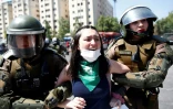 La police anti-émeutes arrête une manifestante, à Santiago le 21 octobre 2019