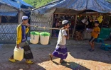 Des enfants rohingyas transportent de l'eau au camp de Nayapara, au Bangladesh, le 26 novembre 2023 