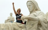 Une manifestante sur la grande statue en marbre de la Justice devant la Cour suprême des Etats-Unis, à Washington, le 6 octobre 2018 après la nomination du juge Brett Kavanaugh